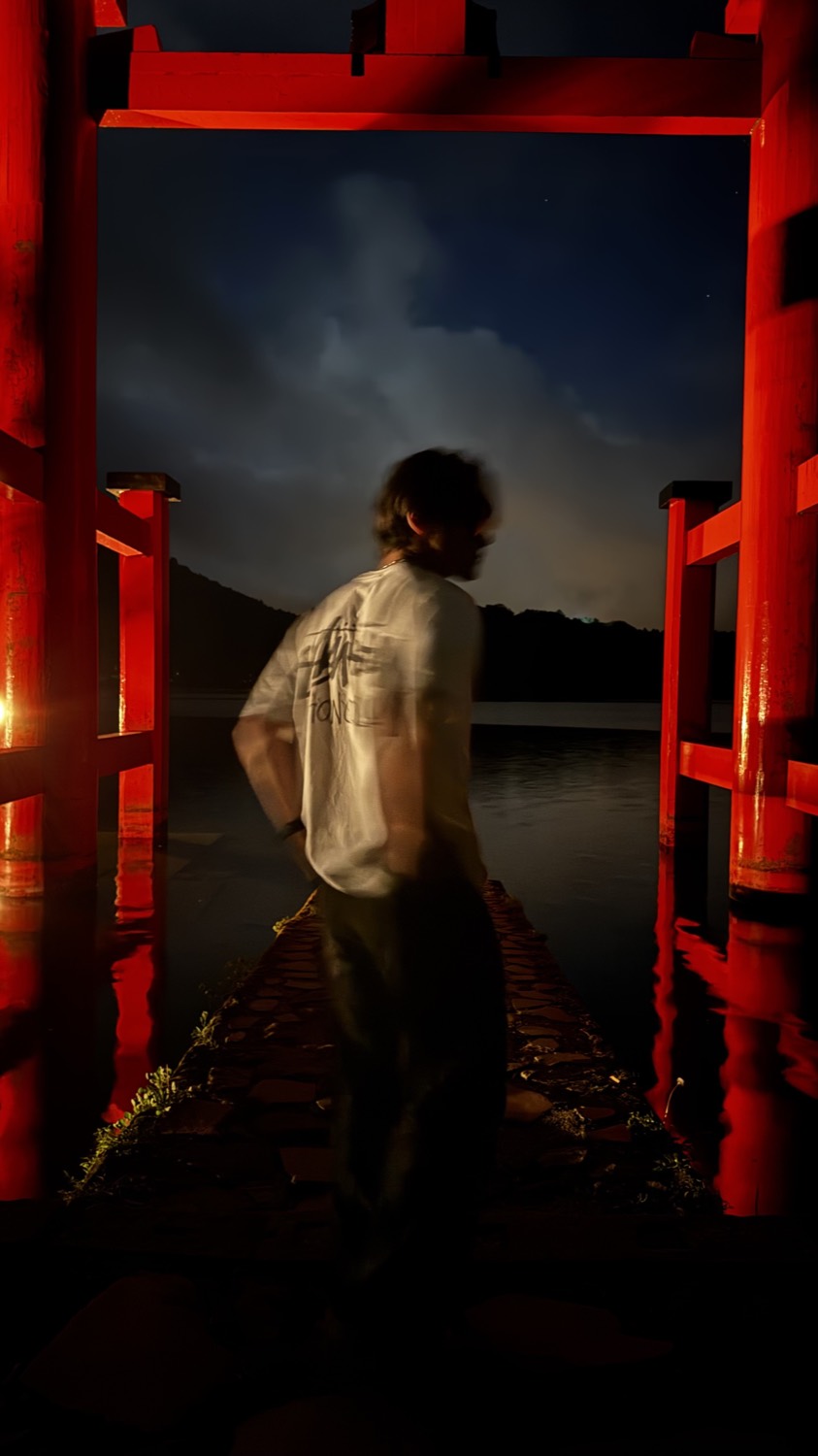 A red torii gate over the water at night, Hakone