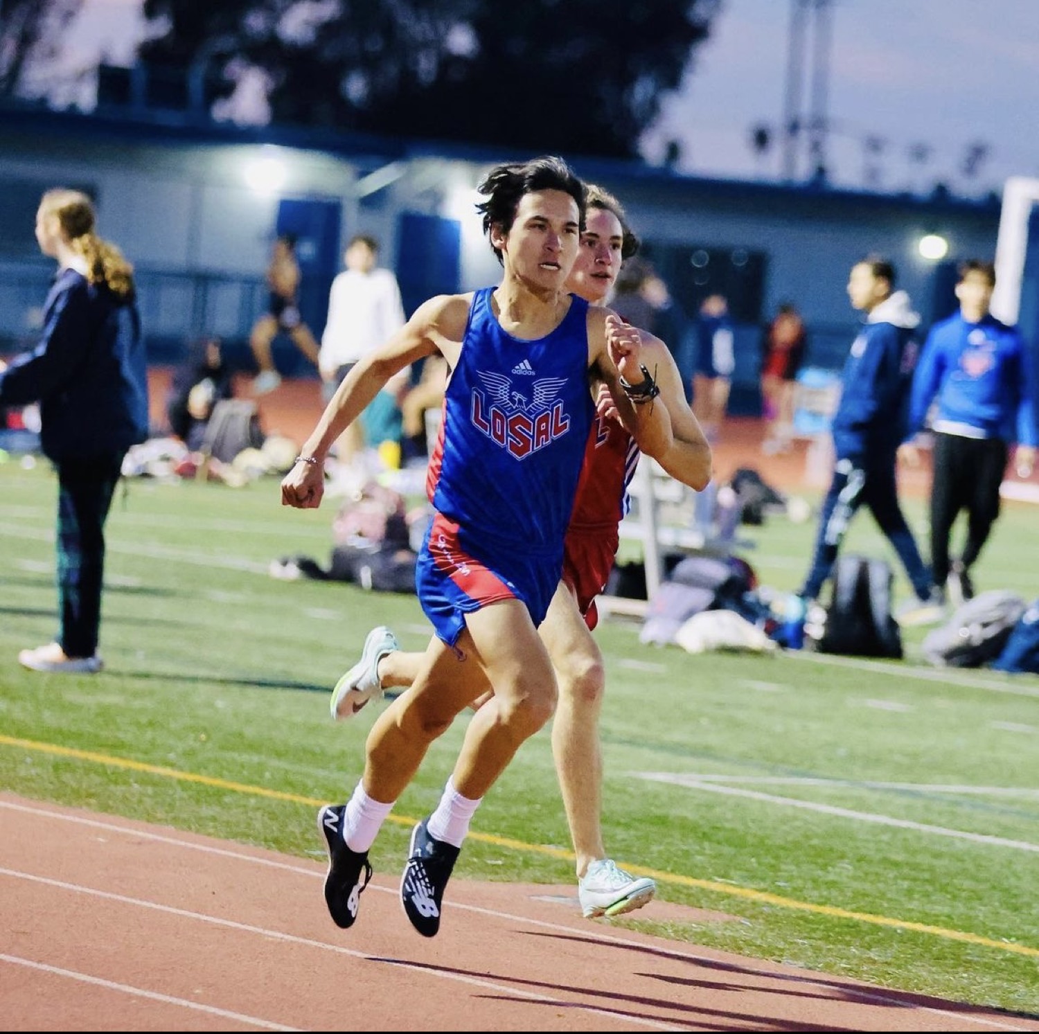 Daniel sprinting on the track under the lights